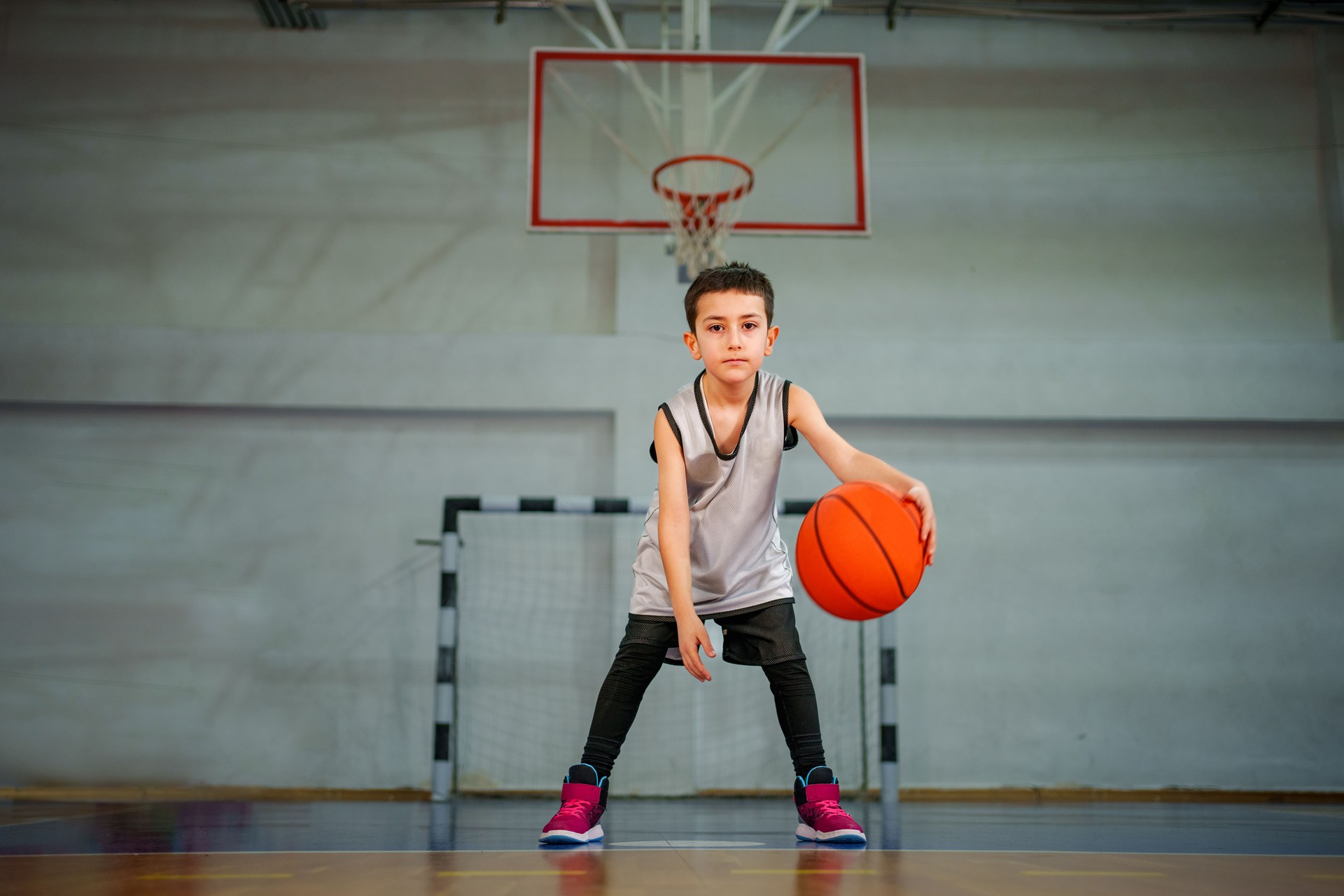 Portrait of a  boy playing basketball in the school gymnasium